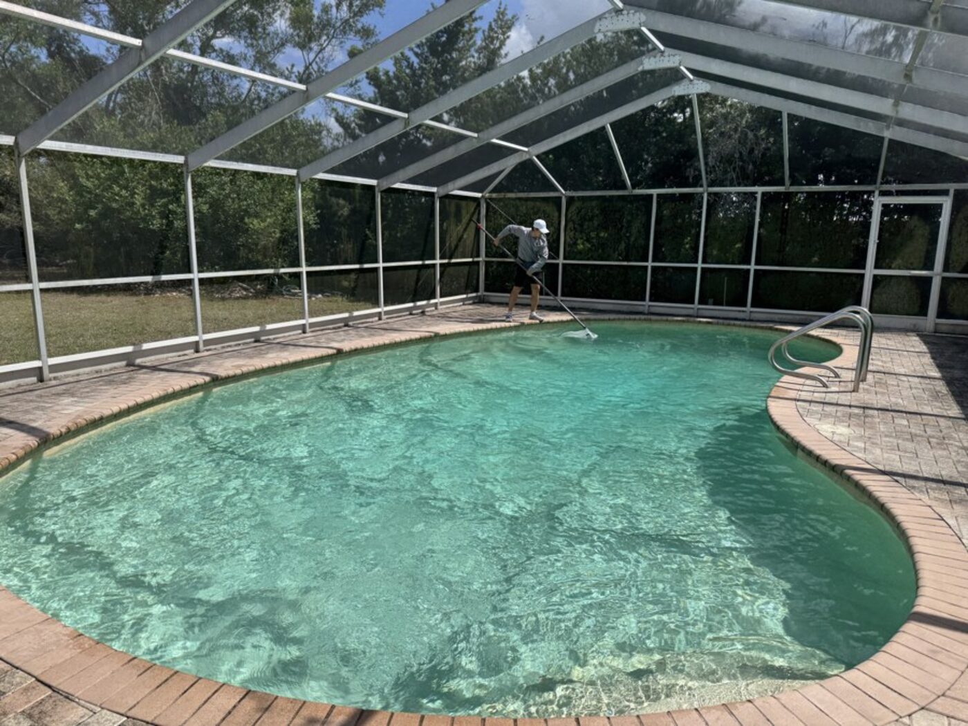 Florida Floyd Pool Services technician servicing a screened pool